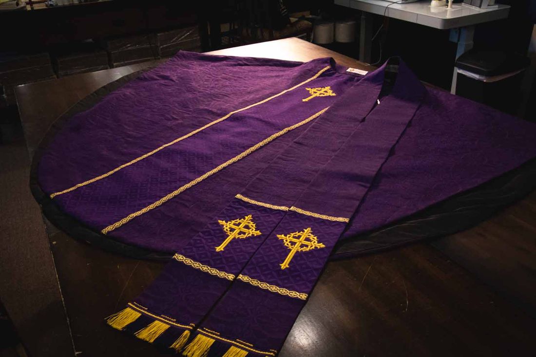 Violet stoles with gold crosses and fringe laid on a chasuble