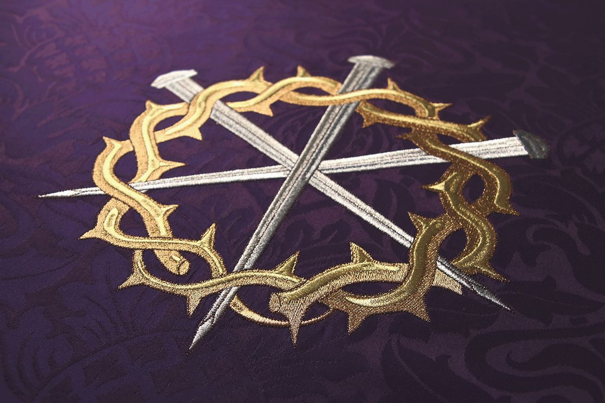 Silver nails crossed inside a gold crown of thorns on violet