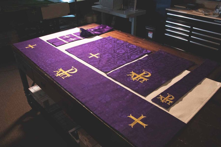 A violet set laid out with gold crosses and a Chi Rho