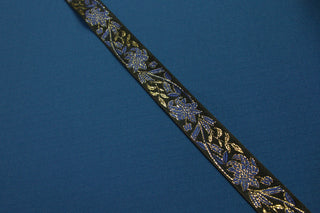 Royal blue gold and black floral jacquard trim displayed on black ecclesiastical brocade fabric