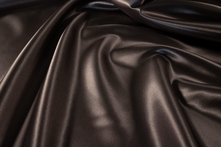Black  Eminence Satin fabric smooth finish close up. Polyester Satin Bridal Fabric. Used for church vestment lining. 