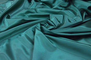 Eminence Satin emerald Jade fabric smooth finish close up. Polyester Satin Bridal Fabric. Used for church vestment lining. 