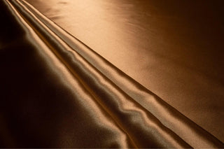 Eminence Satin fabric smooth finish close up. Polyester Satin Bridal Fabric. Used for church vestment lining. 