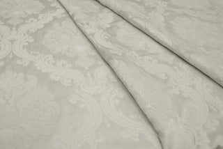 Chenille floral weaving on the satin ground of Ravenna Ivory Brocade folds