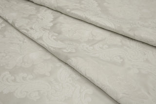Chenille floral weaving on the satin ground of Ravenna Ivory Brocade with fabric folds