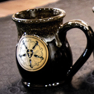 The Luther Rose Cup in Dark Chocolate and Caramel, showing the gold Luther Rose medallion