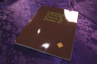 Embroidery for Church Guilds: Single burgundy cover on purple patterned fabric.