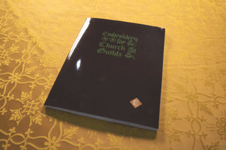 Embroidery for Church Guilds: Front cover displayed on gold floral fabric.