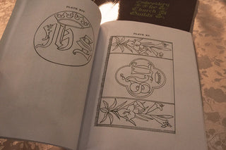 Embroidery for Church Guilds: Open pages showing IHS monograms and floral embroidery designs.