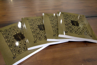 Four copies of A Manual of Church Decoration and Symbolism fanned out on a wood table