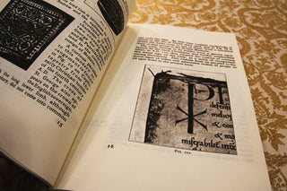 Needlework in Religion: Open pages showing historic text and a Christian monogram.