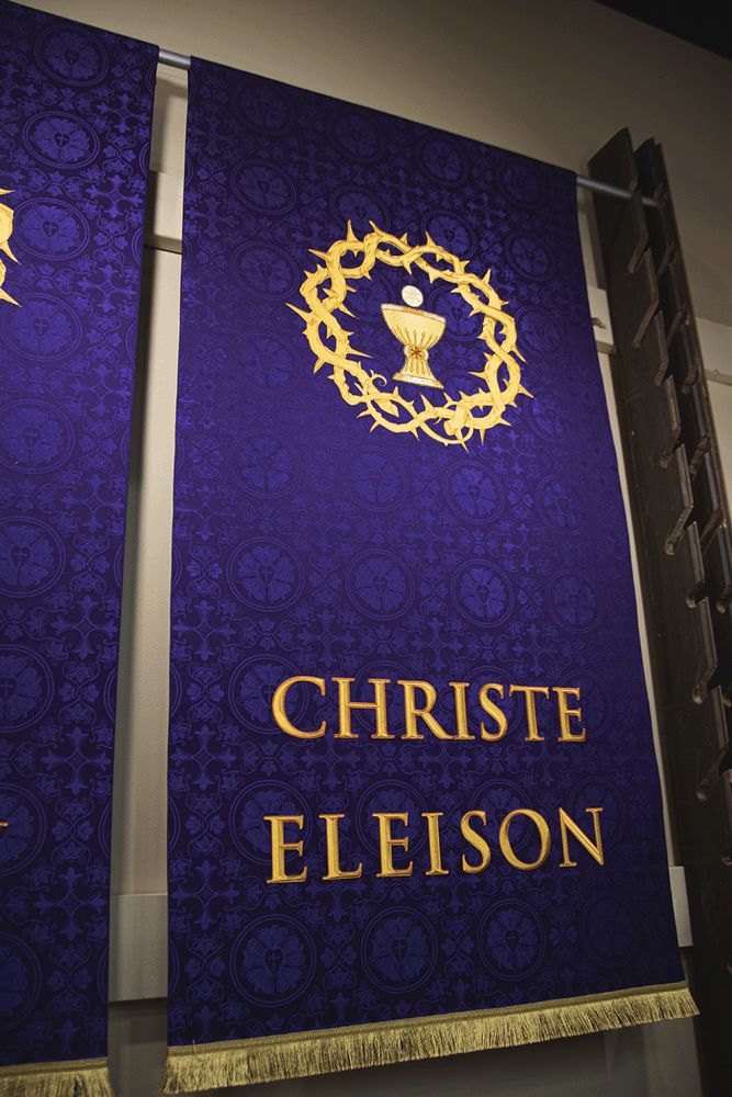 A violet Christe Eleison banner with a chalice inside a crown of thorns