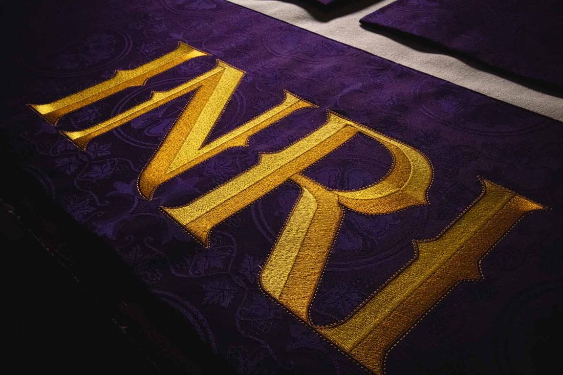 INRI embroidered in gold on violet brocade